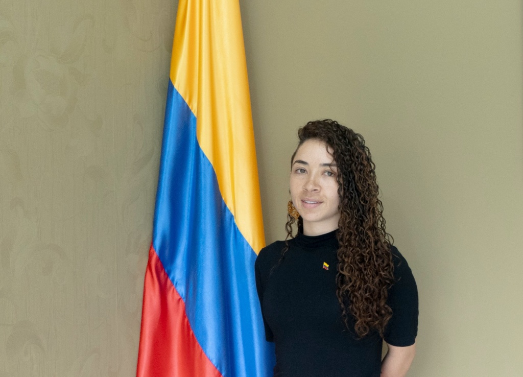 Foto de la cónsul Sandra Milena Trejos Salazar al lado de la bandera de Colombia.